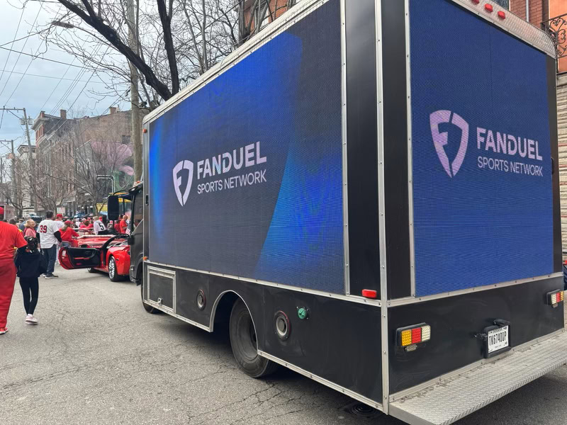 FanDuel Sports Network truck on city street.