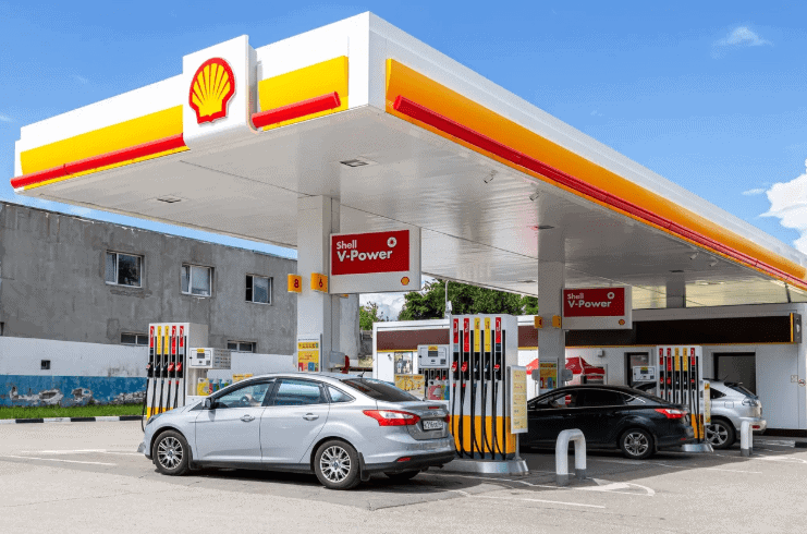 Gas station with Shell branding featuring fuel pumps and vehicles, illustrating gas pump top advertising potential for enhancing brand visibility.