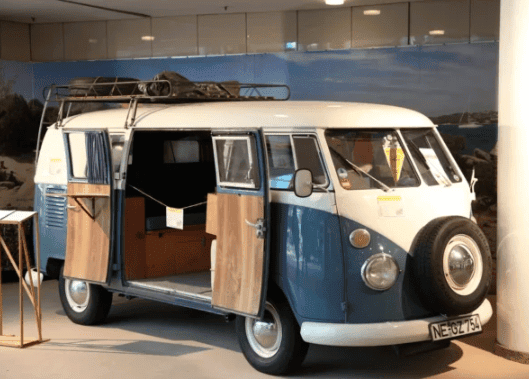 Vintage blue and white mobile fashion truck showcasing an open door, serving as a unique retail space for personalized shopping experiences.