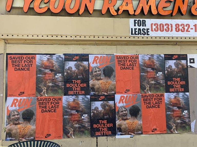 Nike advertising posters on a wall featuring vibrant images and text, promoting themes of running and celebration, alongside a "For Lease" sign above Tycoon Ramen.