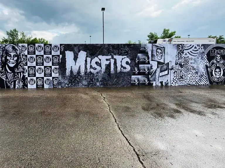 Mural featuring the word "MISFITS" in bold letters, surrounded by various artistic elements and imagery, showcasing urban guerrilla marketing in a public space.