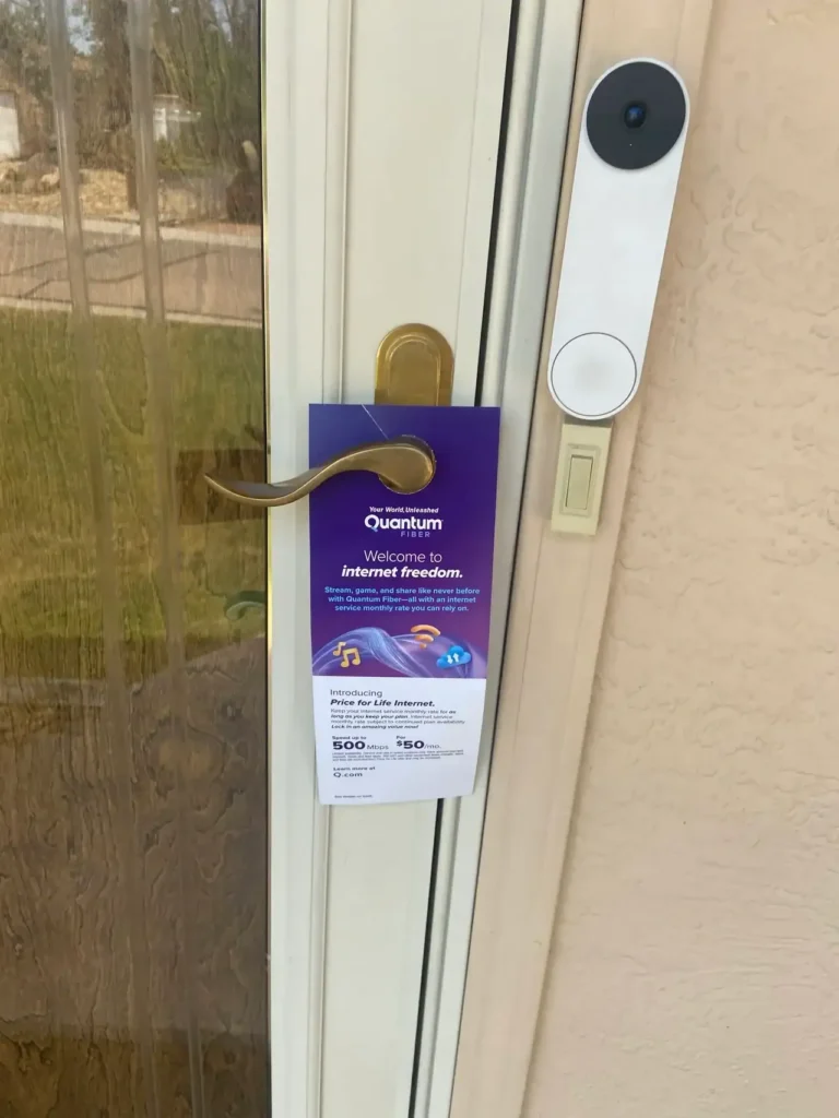 Door hanger advertisement for Quantum internet service, featuring promotional text about "internet freedom" and pricing details, displayed on a door handle.