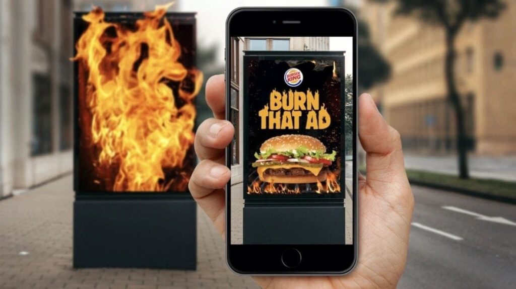 Person using smartphone to interact with augmented reality advertisement featuring a burning burger ad, illustrating innovative AR marketing strategies.