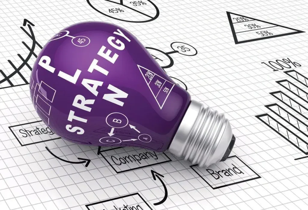 Purple light bulb labeled "PLAN STRATEGY" on graph paper with marketing charts and diagrams, symbolizing innovative marketing strategies and brand planning.