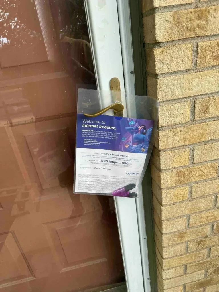 Door hanger advertising promoting internet service with the message "Welcome to internet freedom," featuring details about a 500 Mbps plan for $50, displayed on a residential door.