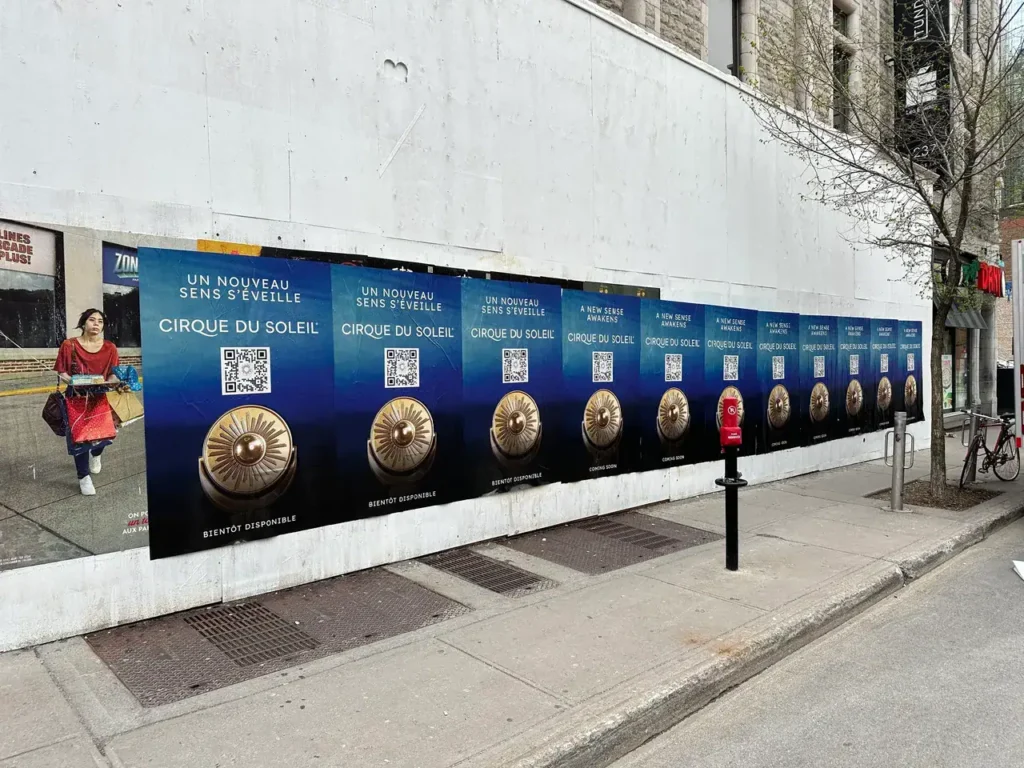 Guerrilla marketing campaign for Cirque du Soleil featuring multiple promotional posters with QR codes and French text on a city wall in Surrey, British Columbia.