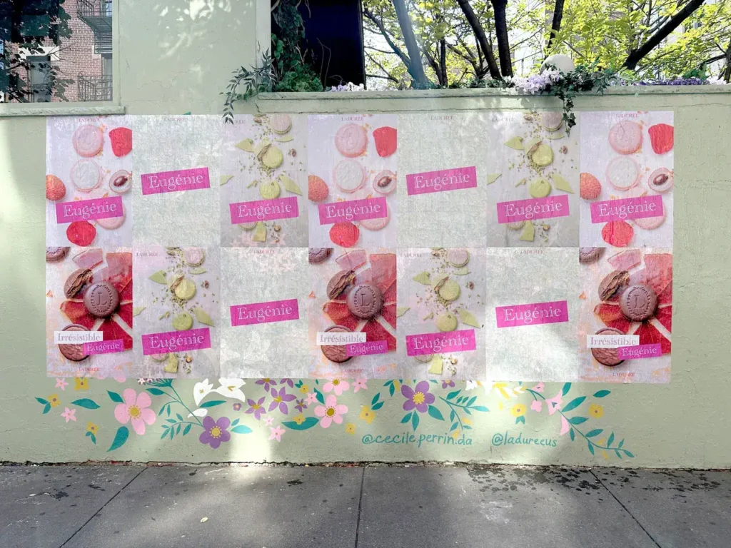 Colorful mural featuring multiple advertisements for "Eugenie" with macaron imagery, promoting a dessert brand, set against a floral backdrop, relevant to guerrilla marketing strategies.