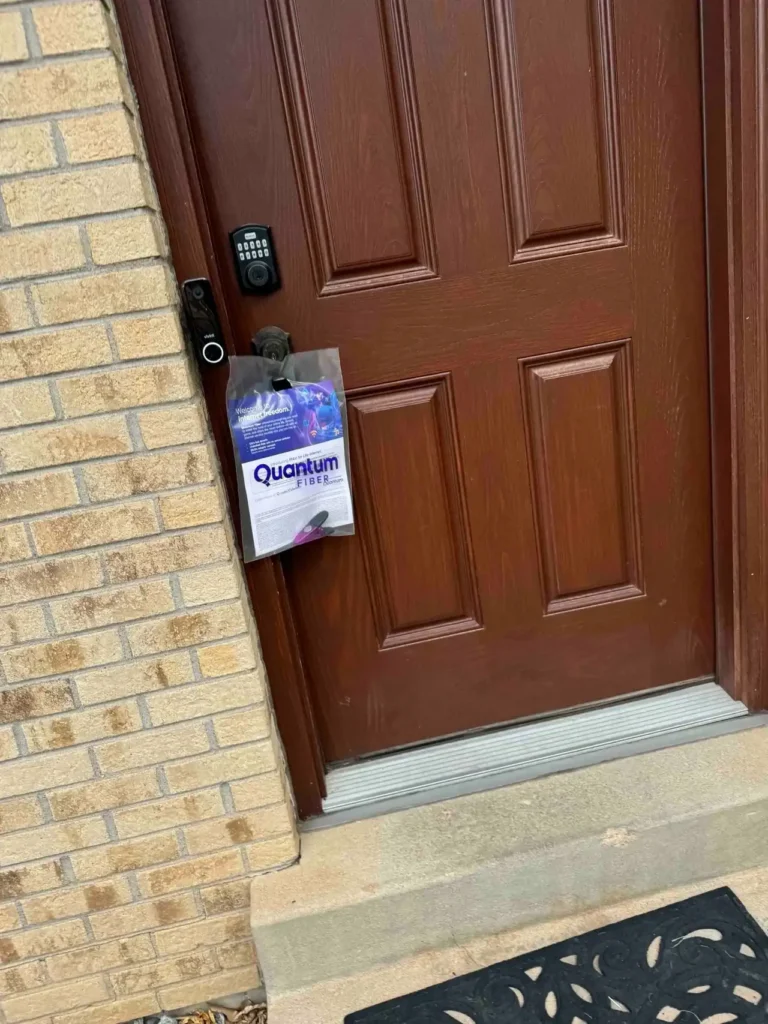 Door hanger advertising for Quantum Fiber displayed on a residential door, showcasing hyperlocal marketing strategy.