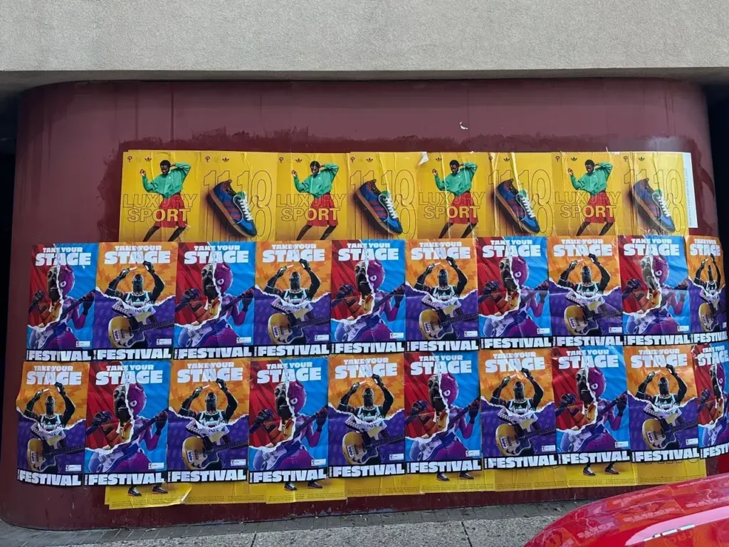 Colorful promotional posters covering a wall, advertising a festival and encouraging participation on stage, with a sports theme.