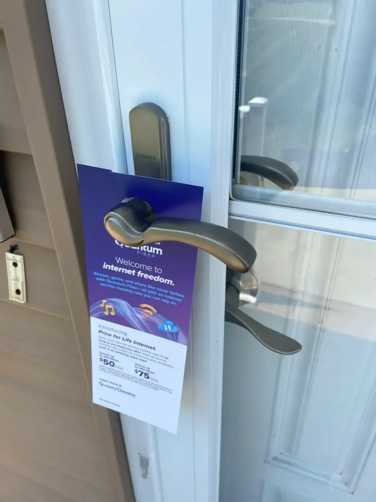 Door hanger promoting internet services, featuring a welcome message and pricing details, attached to a residential door handle.