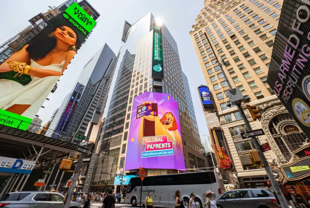 Times Square in New York City featuring vibrant digital billboards, including an advertisement for "Global Payments" alongside a colorful animated character, showcasing guerrilla marketing in a hyperlocal urban setting.