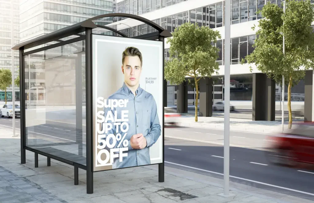 Bus stop advertising display featuring a young man promoting a "Super Sale Up to 50% Off," showcasing effective transit marketing strategies relevant to bus advertising services.
