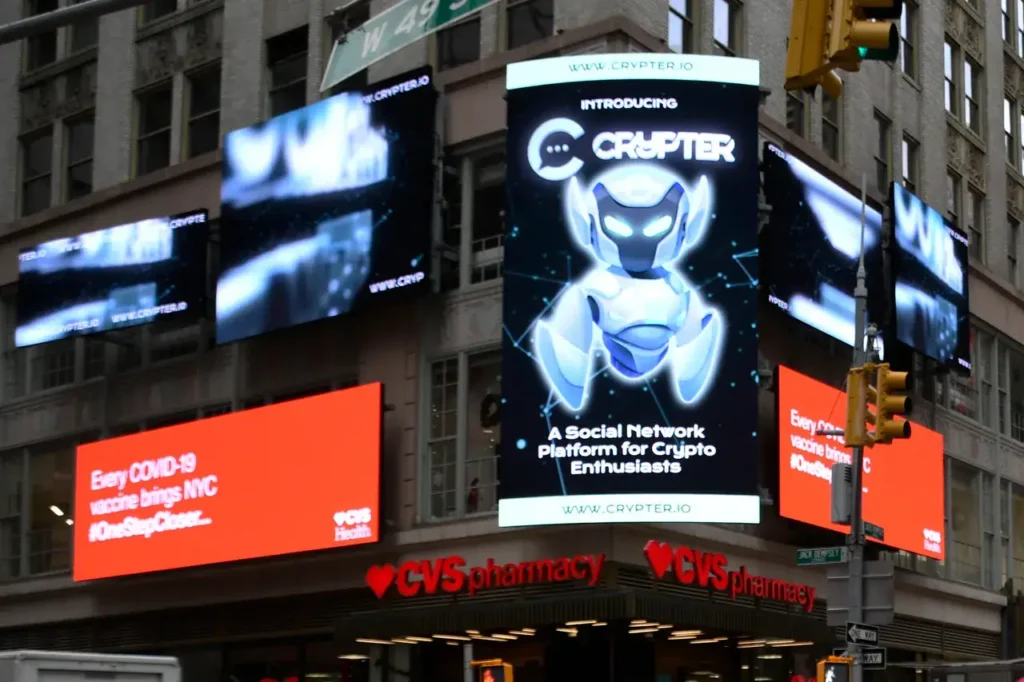 Digital billboard advertisement for Crypter, featuring a futuristic robot design and text promoting it as a social network platform for crypto enthusiasts, set against a backdrop of urban architecture.