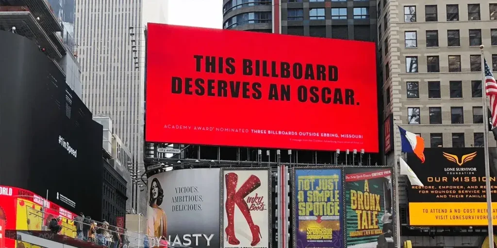 Billboard advertisement in Times Square reading "THIS BILLBOARD DESERVES AN OSCAR" with surrounding commercial signage, illustrating impactful guerrilla marketing strategies.