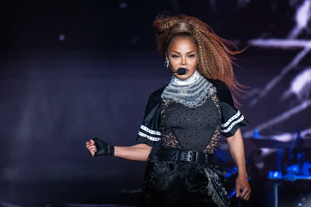 Janet Jackson performing on stage with dynamic expression and intricate costume design.