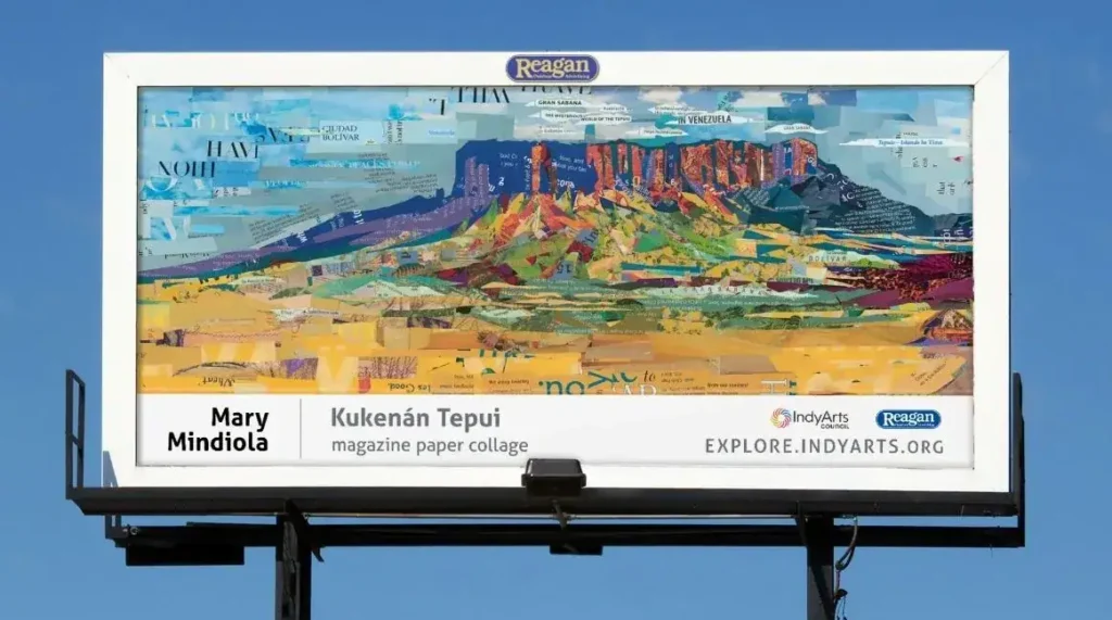 Billboard featuring Mary Mindiola's "Kukenán Tepui," a vibrant magazine paper collage artwork, displayed prominently in an outdoor setting.