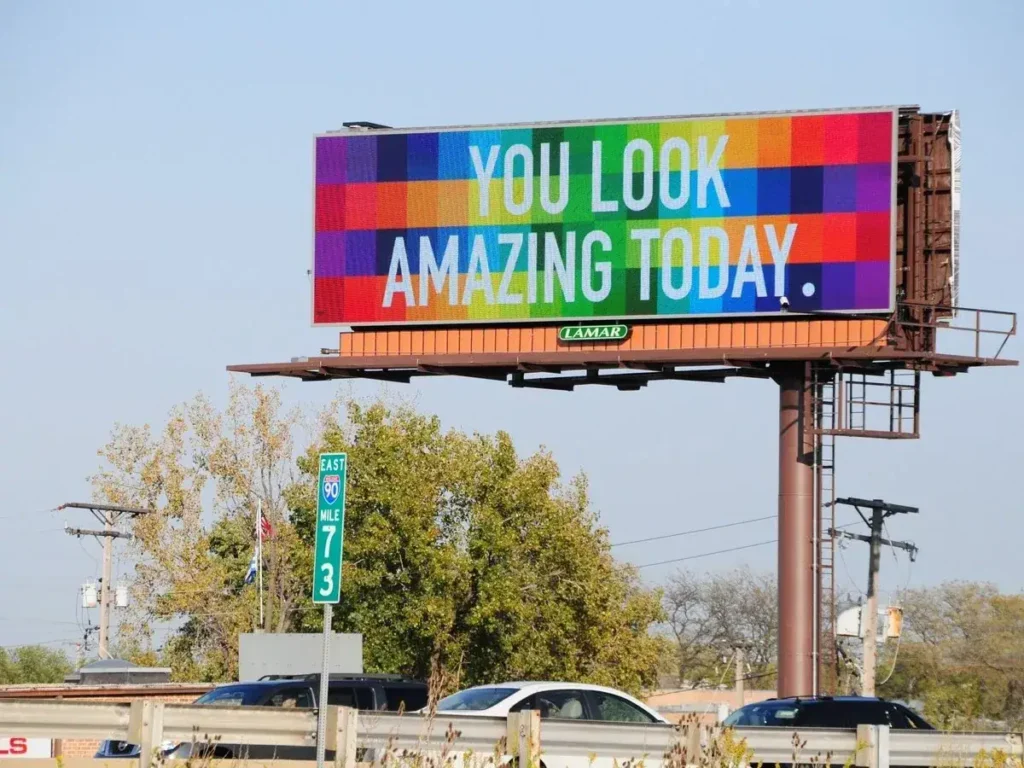 Billboard displaying colorful text "YOU LOOK AMAZING TODAY" promoting positive messaging in outdoor advertising.