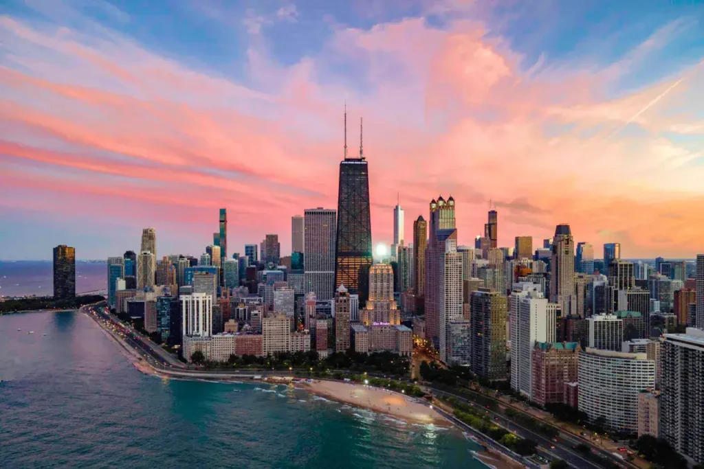Chicago skyline at sunset with prominent skyscrapers and Lake Michigan shoreline, illustrating urban marketing potential for advertising agencies.