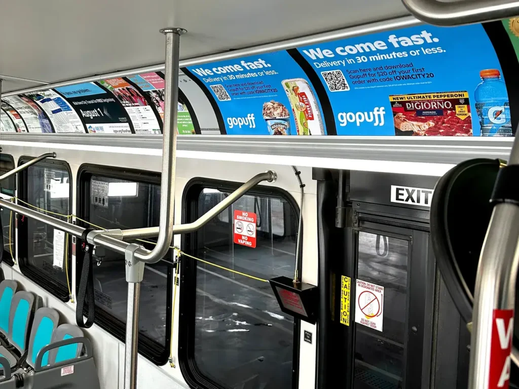 Interior of a bus featuring advertisements for Gopuff, highlighting fast delivery services and various food products, relevant to guerrilla marketing strategies for urban advertising.
