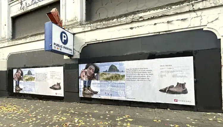 Forsake boots ad on building wall.