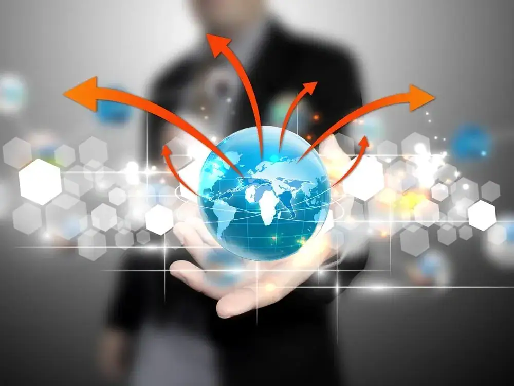 Global marketing concept with a hand holding a globe and arrows indicating international outreach.