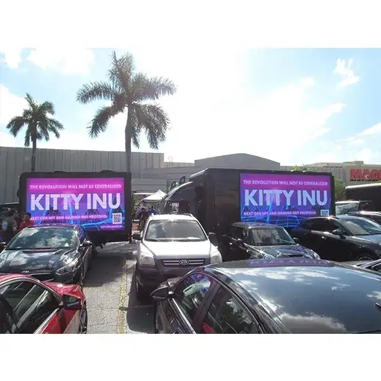Billboard trucks displaying "KITTY INU" advertising in a busy parking lot, promoting guerrilla marketing strategies for innovative brand visibility.