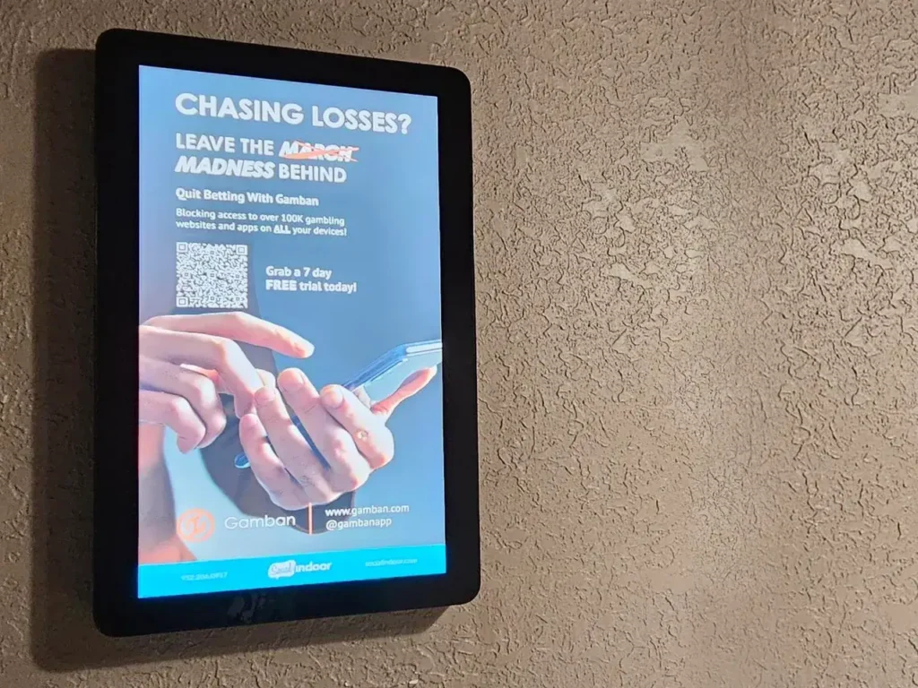 Digital advertisement for Gamban promoting responsible betting, featuring hands holding a smartphone, with text urging users to quit gambling and offering a free trial.