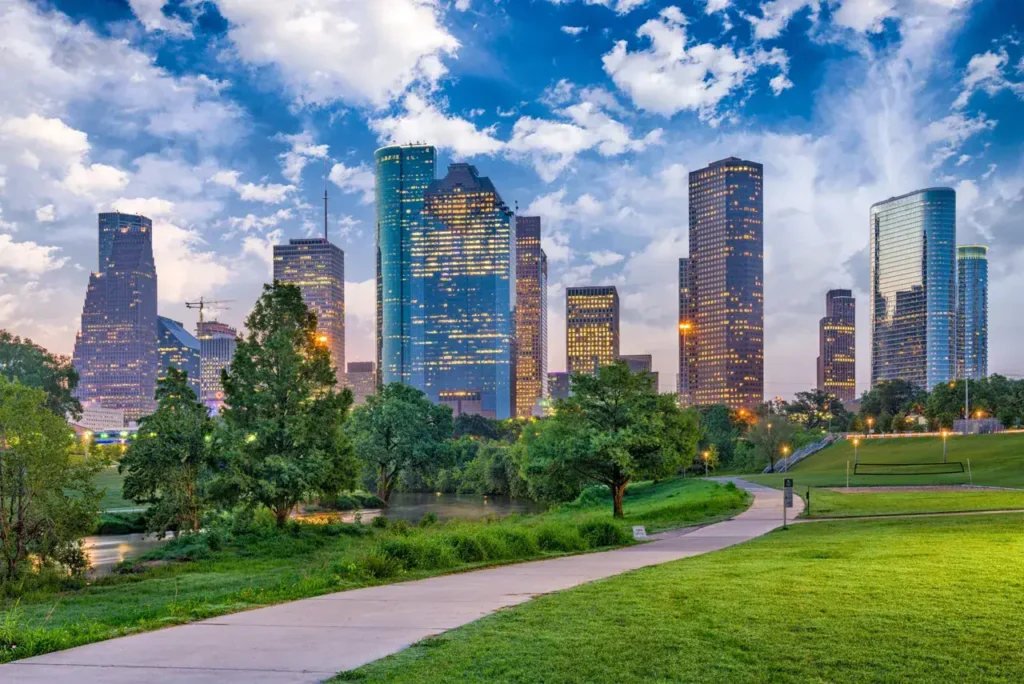 Houston skyline with modern skyscrapers, green park area, and blue sky, representing urban landscape and advertising potential in Houston.