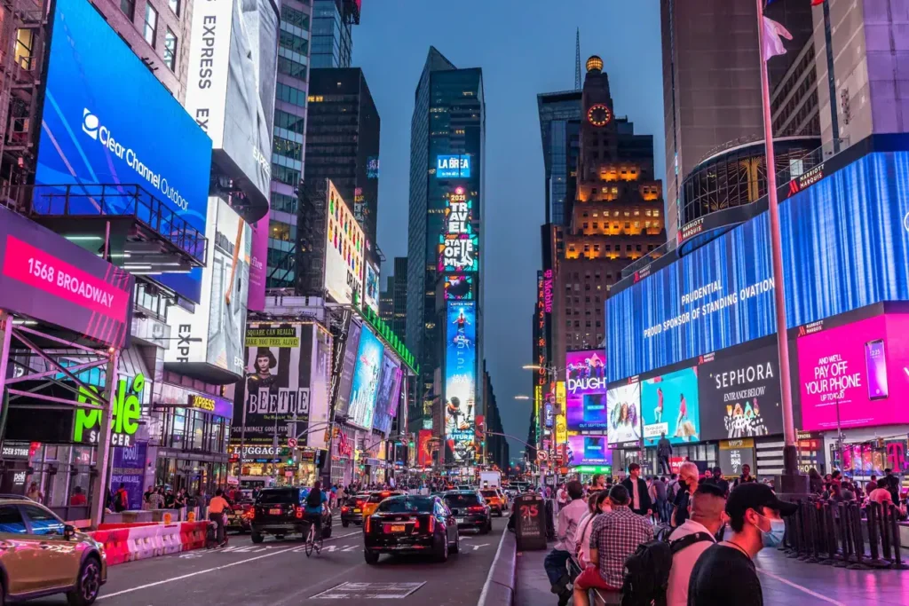 Times Square at dusk featuring vibrant LED billboards, bustling traffic, and pedestrians, illustrating a key location for high-impact advertising and marketing strategies.