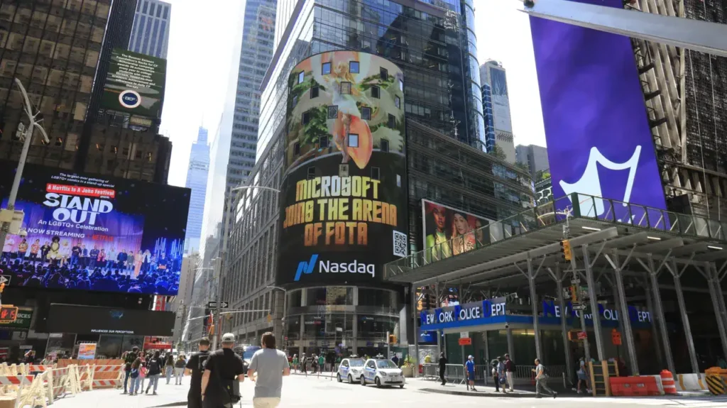 Digital billboard advertising in Times Square featuring Microsoft and Nasdaq, surrounded by pedestrians and urban architecture.