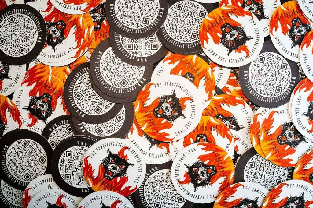 Promotional coasters featuring a fiery black wolf design and QR codes, illustrating guerrilla marketing strategies for bars and restaurants.