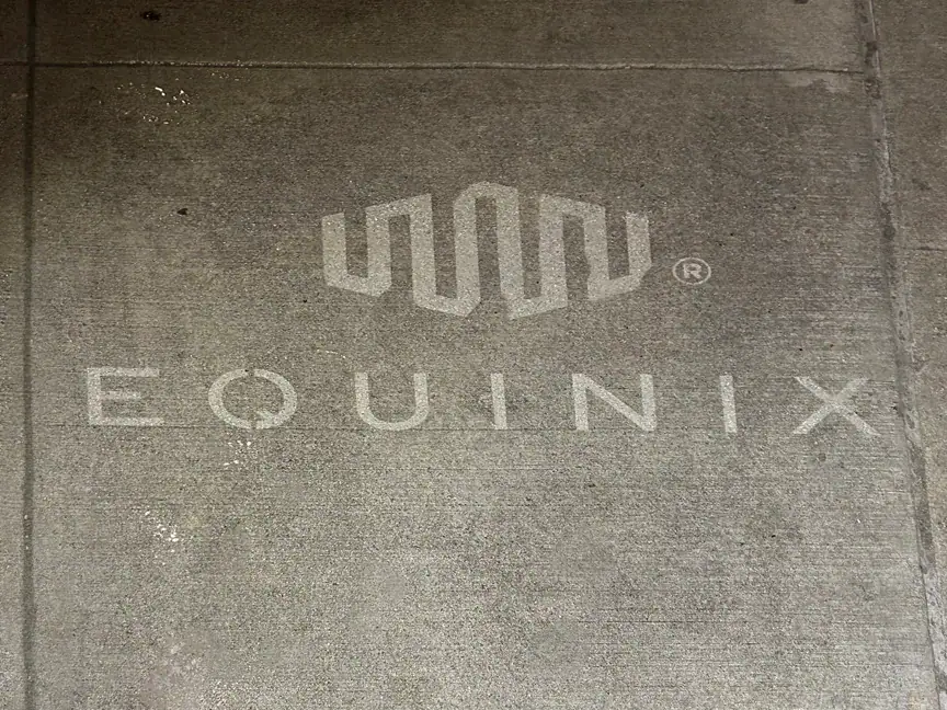 Equinix logo displayed on concrete surface, representing branding and advertising strategies for businesses.