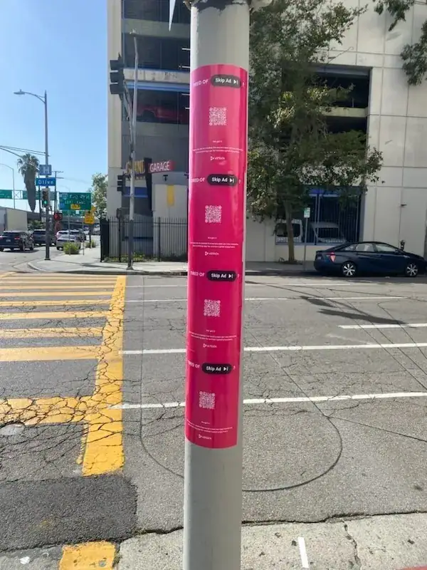 Pink street pole with QR code ads.