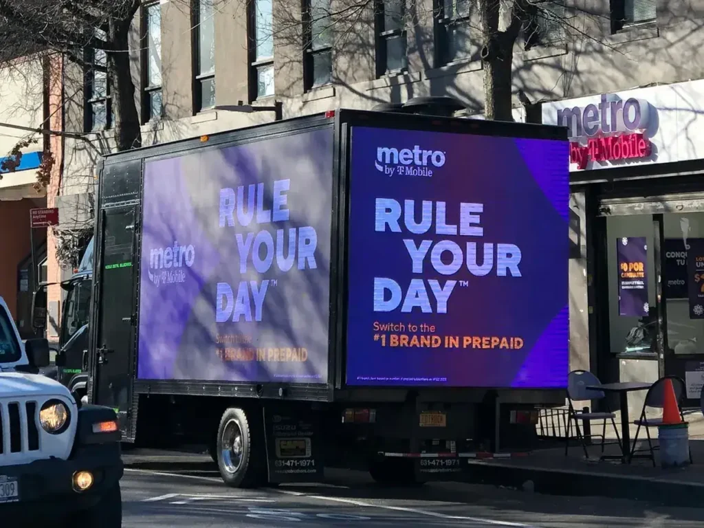 LED billboard truck displaying Metro by T-Mobile advertisement featuring the slogan "Rule Your Day" and promoting prepaid services, set in an urban environment.