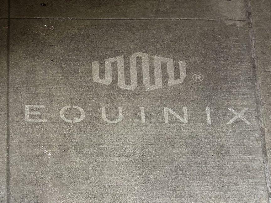 Equinix logo and branding stencil on concrete surface, showcasing innovative street advertising strategy.