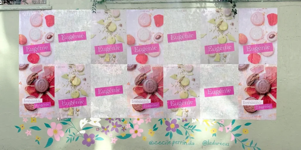 Colorful wall advertisement featuring macaron desserts, displaying the name "Eugénie" and the word "Irresistible," promoting a confectionery brand with floral accents at the bottom.