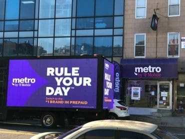 LED billboard truck advertising "Rule Your Day" by Metro in front of a Metro store, showcasing mobile marketing effectiveness.
