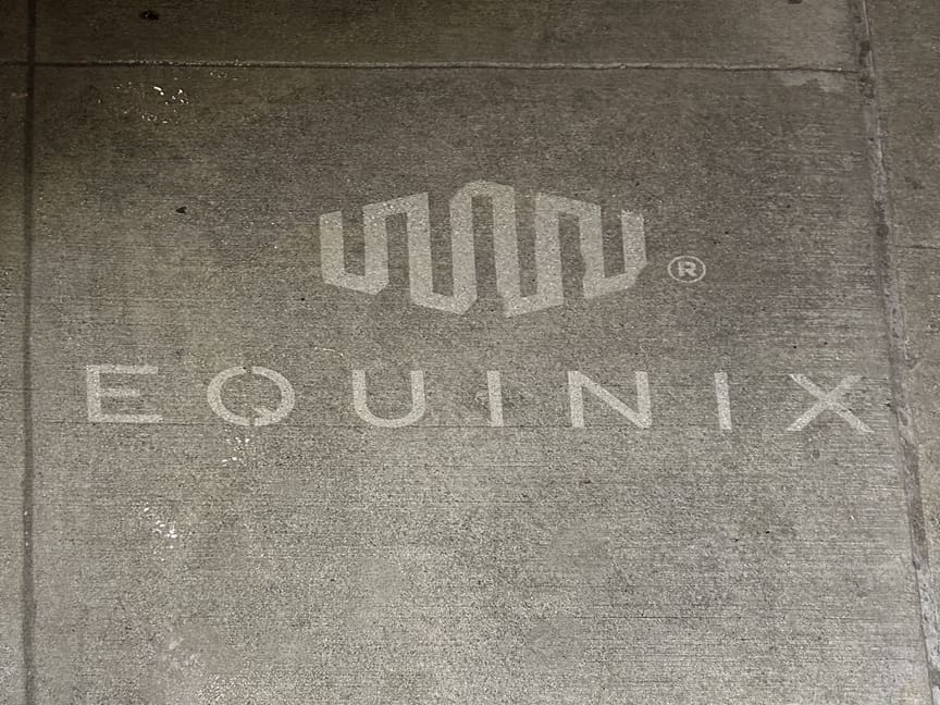 Equinix logo displayed on concrete surface, representing branding strategy in guerrilla marketing.