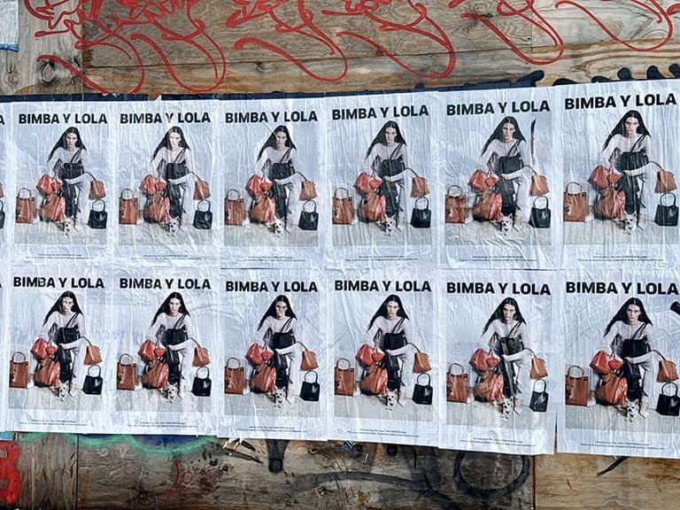 Bimba y Lola advertising posters featuring a model with bags, promoting brand visibility in urban guerrilla marketing.
