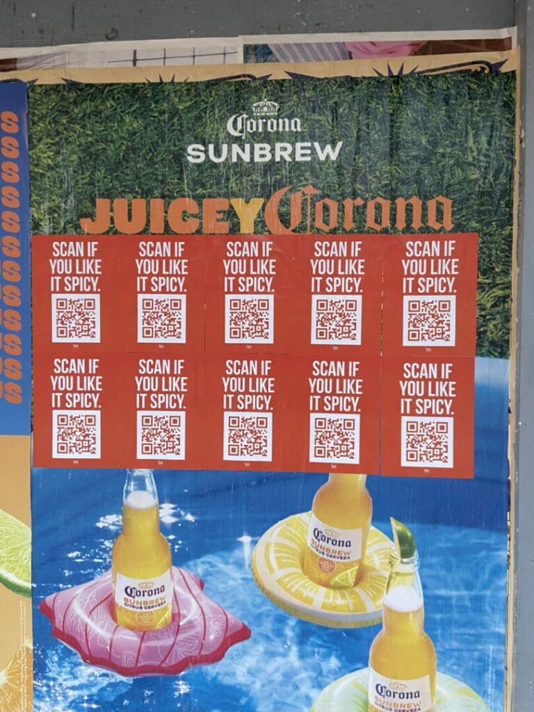 Juicy Corona advertisement featuring QR codes and the text "Scan if you like it spicy," promoting Corona Sunbrew on a vibrant background with floating drink displays.