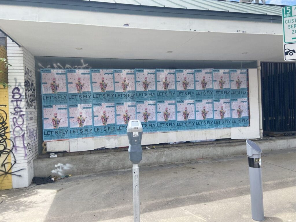 Wall covered with promotional posters reading "LET'S FLY," showcasing guerrilla marketing techniques in urban settings, relevant to college student marketing strategies.