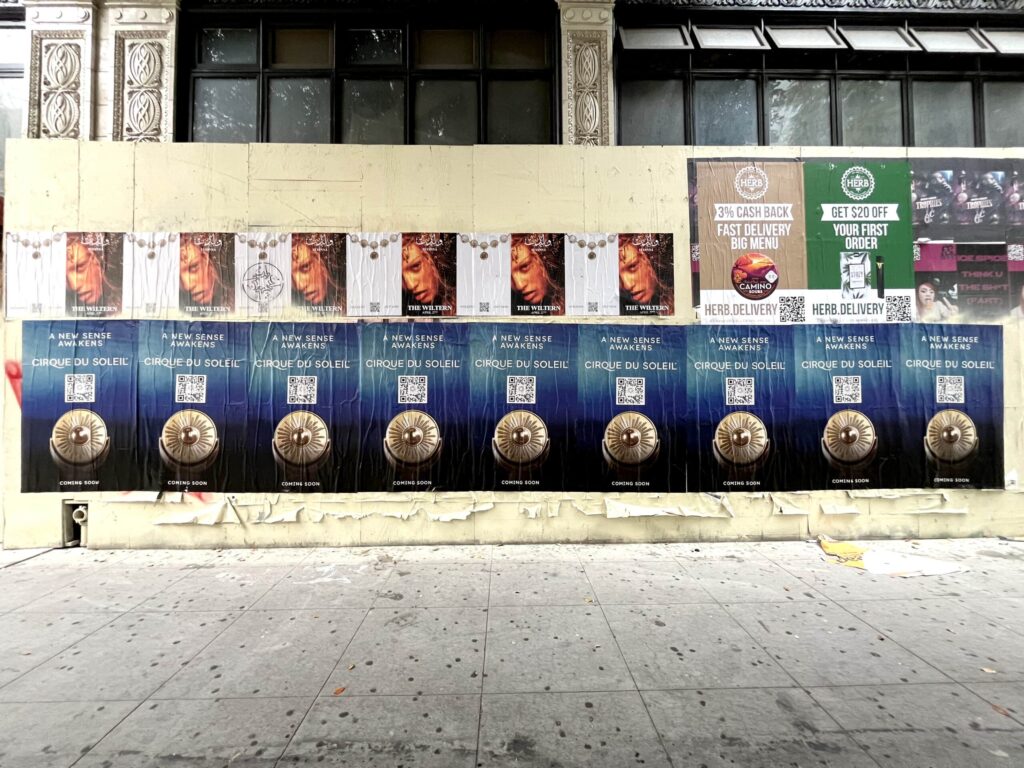 Street posters on an urban wall.