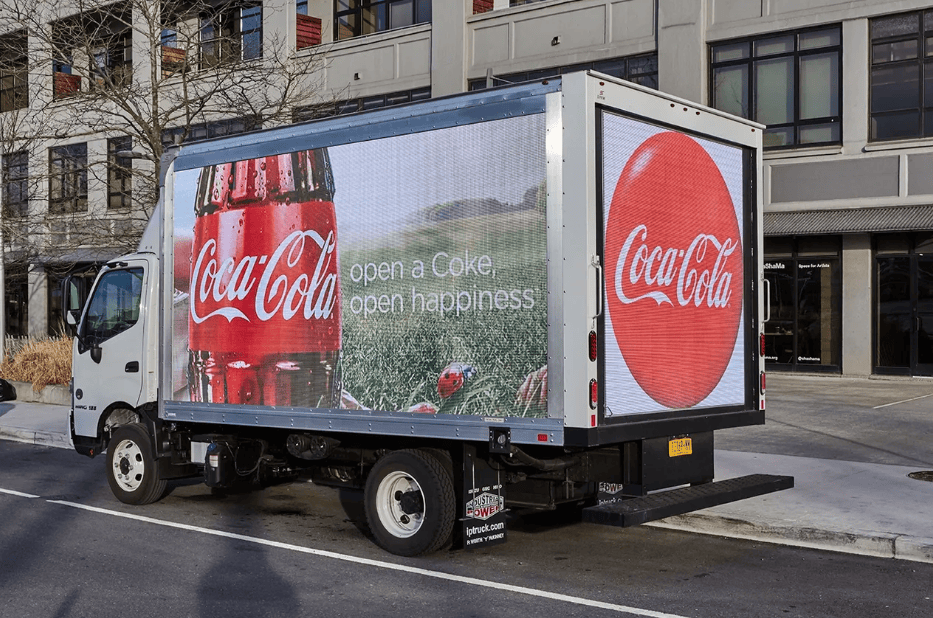 Truck with Coca-Cola advertisement parked outside.