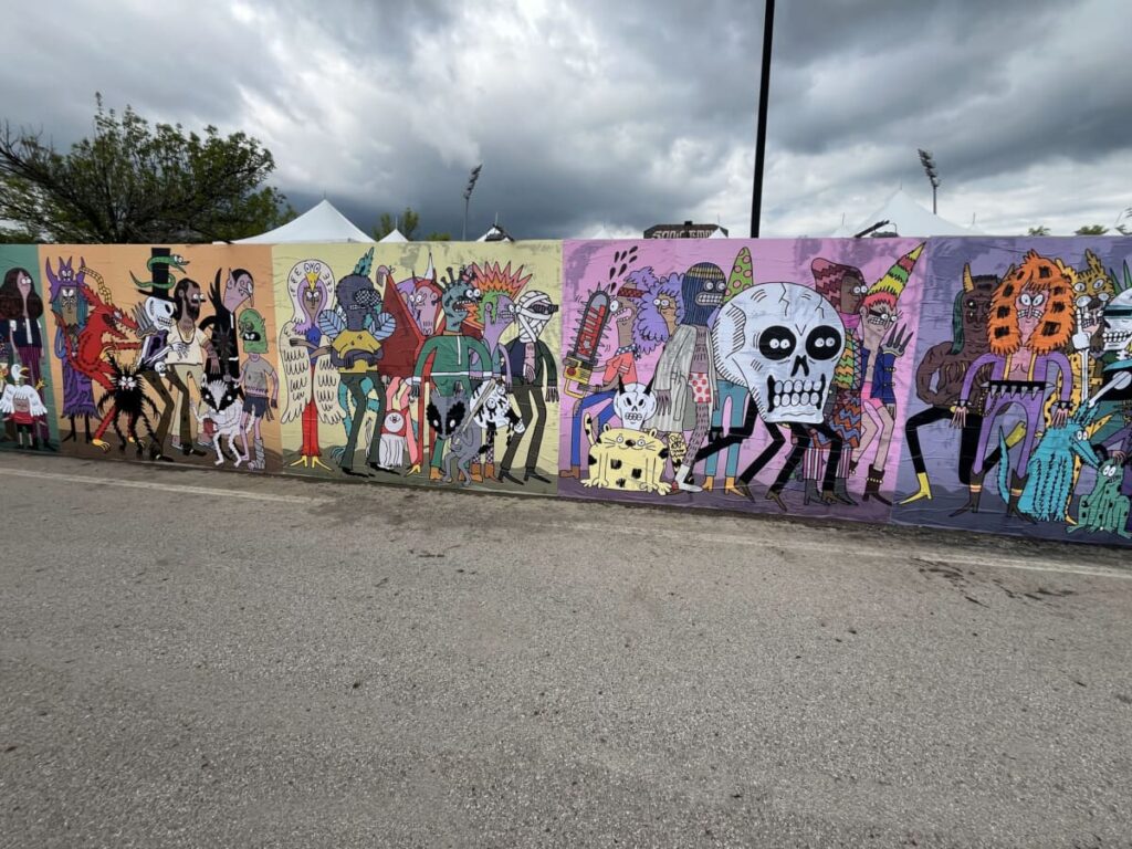 Vibrant street mural featuring diverse, whimsical characters and creatures, showcasing the creative potential of wheatpasting in urban advertising contexts.