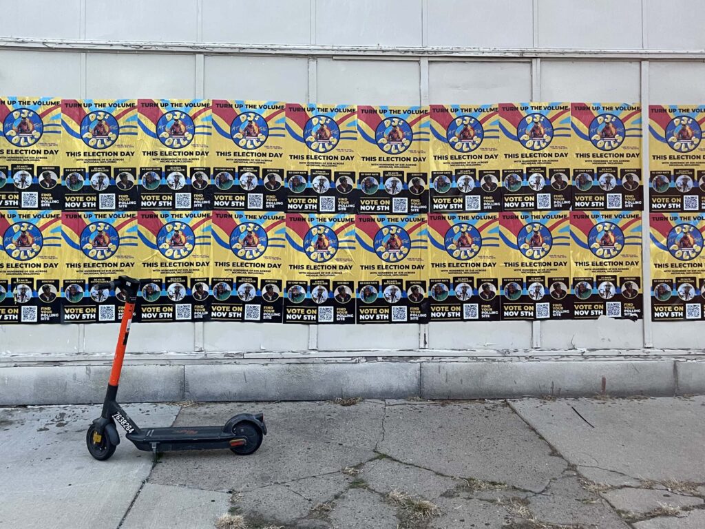Scooter parked by colorful election posters.