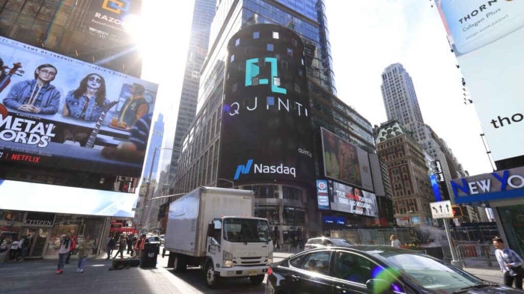 Billboard advertising in Times Square featuring QUINT and Nasdaq logos, showcasing prominent digital displays and urban traffic.