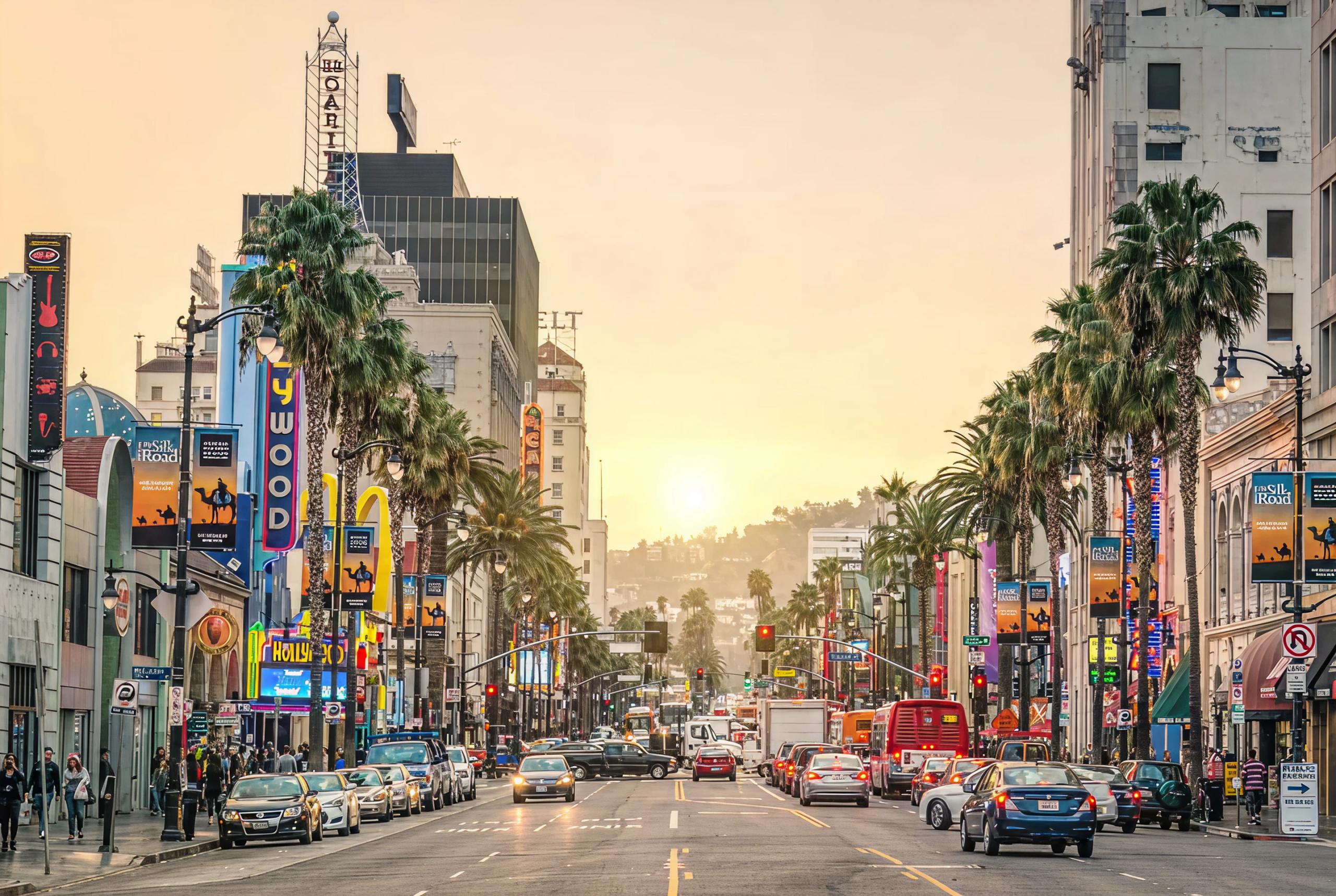 Los Angeles street scene at sunset, featuring palm trees, busy traffic, and vibrant billboard advertisements, highlighting the city's dynamic advertising landscape.