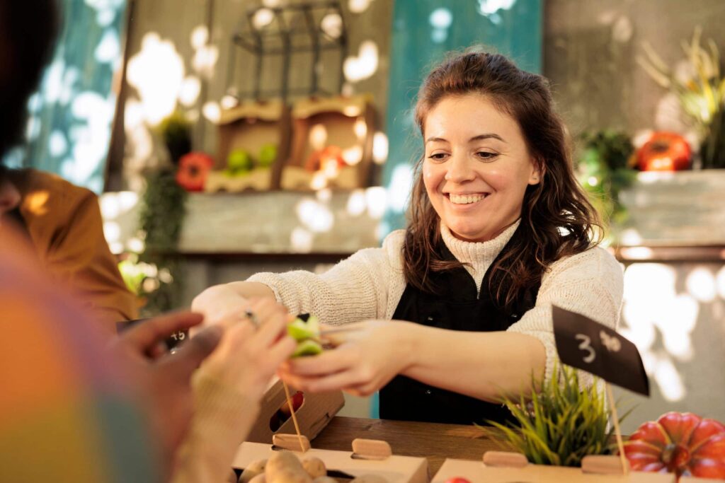 Smiling woman at outdoor market stall.