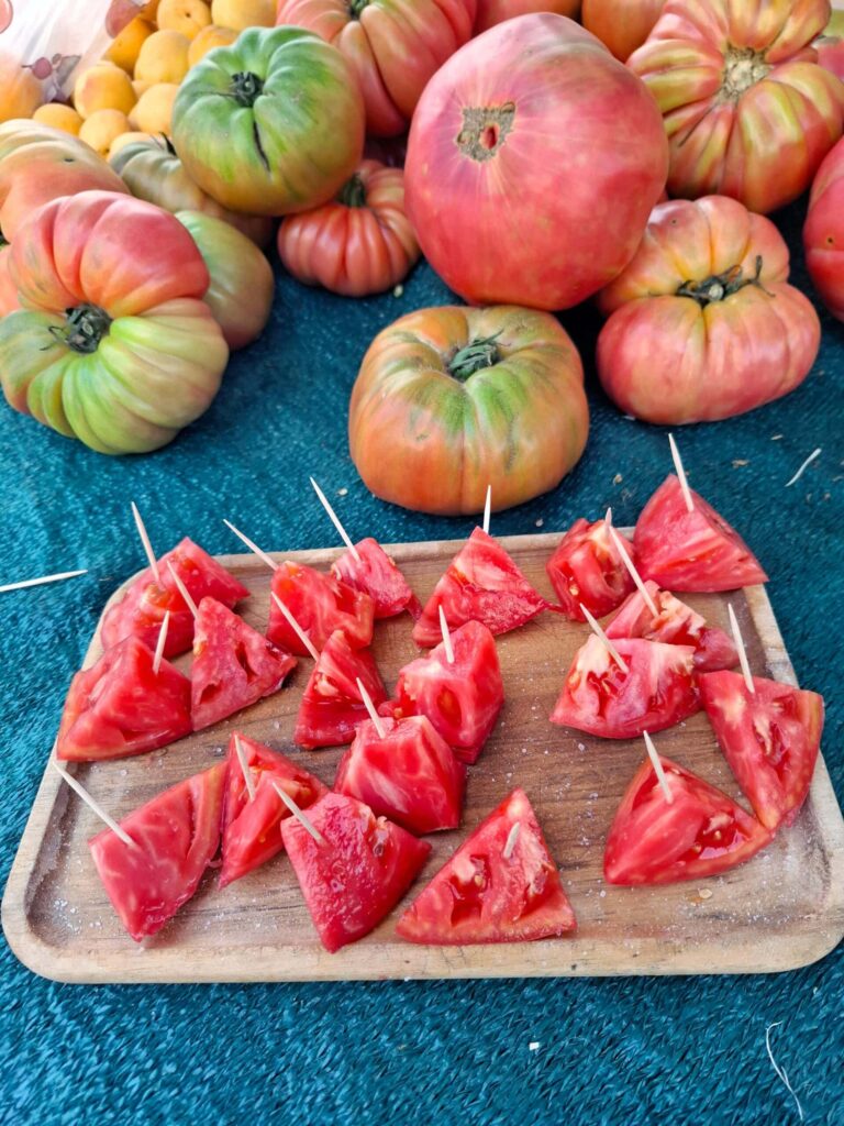 Tomato wedges with toothpicks on wooden tray.