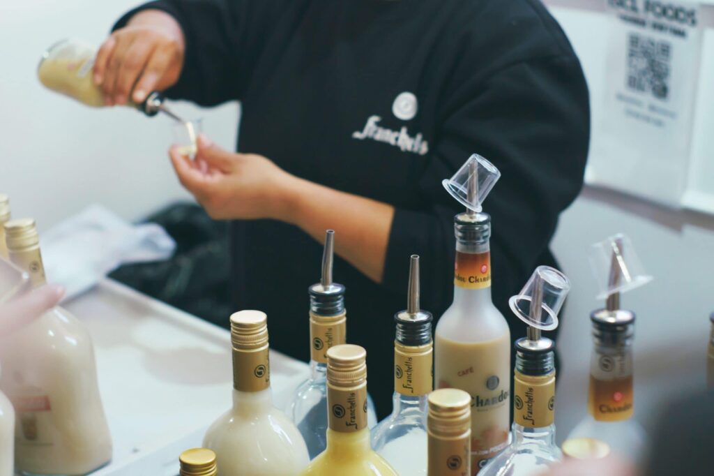 Bartender preparing drinks with cream liqueurs.